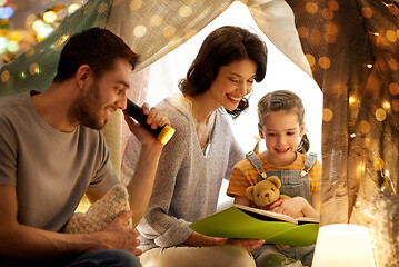 Image showing happy family reading book in kids tent at home