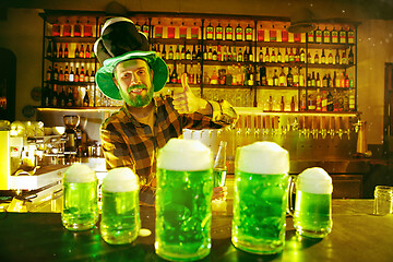 Image showing Happy man with glass of beer looking aside in pub