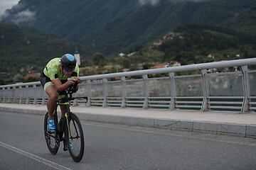 Image showing triathlon athlete riding a bike on morning training