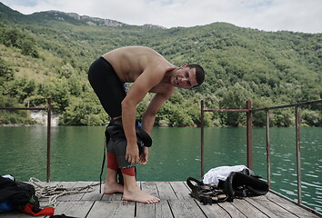 Image showing triathlon athlete getting ready for swimming training on lake