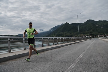 Image showing triathlon athlete running on street