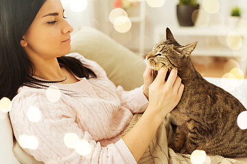 Image showing close up of woman with tabby cat in bed at home