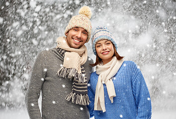 Image showing happy couple in winter clothes over snow