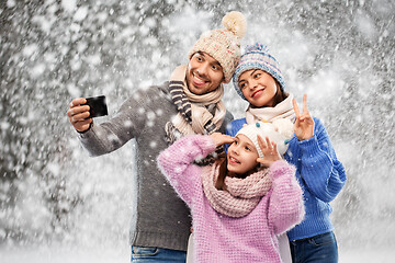 Image showing happy family taking selfie by smartphone over snow