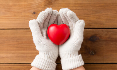 Image showing hands in white woollen gloves holding red heart