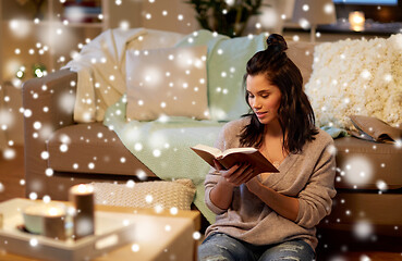 Image showing happy young woman reading book at home