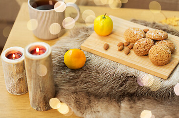 Image showing cookies, lemon tea and candles on table at home