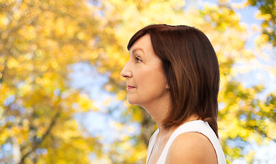 Image showing profile of senior woman over autumn trees