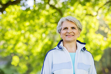 Image showing smiling sporty senior woman at summer park