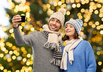 Image showing couple taking selfie by smartphone on christmas