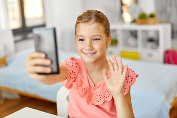 Image showing happy girl with smartphone taking selfie at home