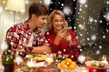 Image showing couple with smartphone at home christmas dinner