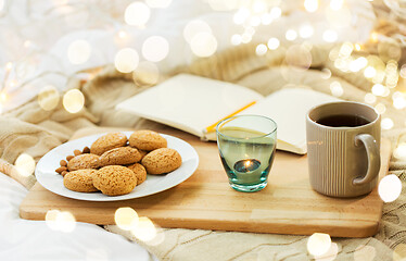 Image showing cookies, tea and candle in holder at home