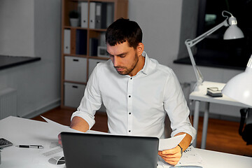 Image showing businessman with papers working at night office