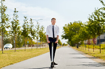 Image showing young businessman riding electric scooter outdoors