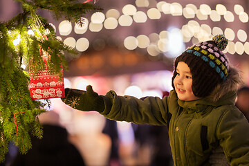 Image showing boy reaching to gift bag hanging on christmas tree