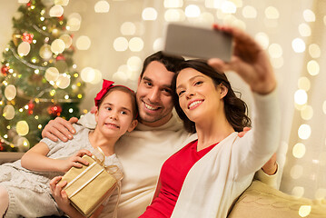 Image showing happy family with christmas present at home