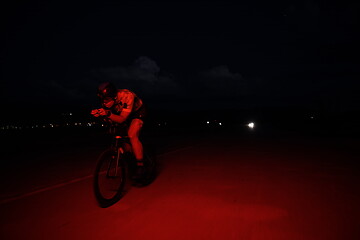 Image showing triathlon athlete riding bike fast at night