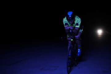Image showing triathlon athlete riding bike fast at night