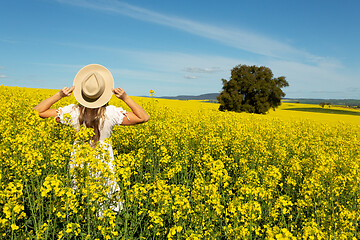 Image showing Woman in white dress in field of golden canola