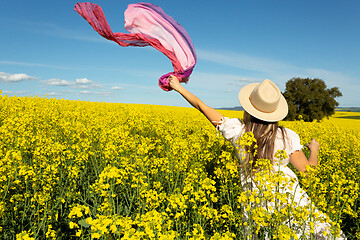 Image showing Woman in whte dress and floating scarf in canola field