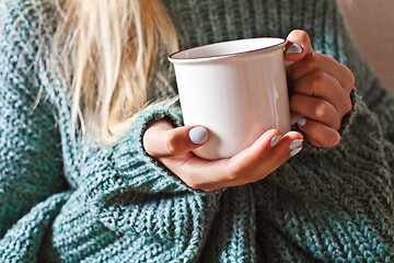 Image showing Female hands holding mug of hot tea with lemon in morning.