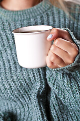 Image showing Female hands holding mug of hot tea with lemon in morning.