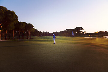 Image showing golfer hitting ball to hole