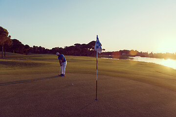 Image showing golfer hitting ball to hole