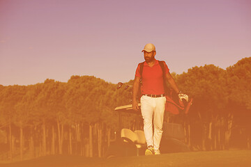 Image showing golfer  walking and carrying golf  bag