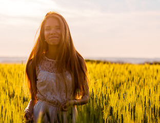 Image showing Happy girl in wheat field at sunset