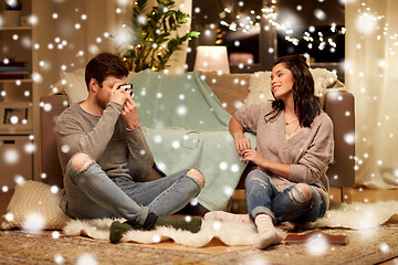 Image showing happy couple with camera photographing at home