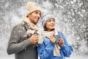 Image showing happy couple in winter clothes with mugs