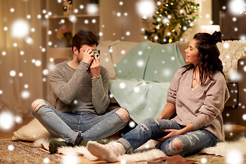 Image showing happy couple with camera photographing at home