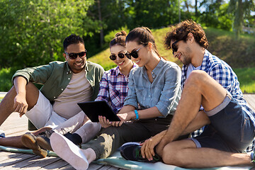 Image showing friends with tablet pc computer outdoors in summer