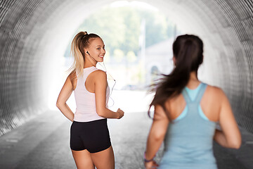 Image showing women or female friends with earphones running