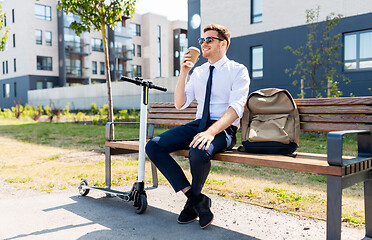 Image showing businessman with scooter drinking coffee in city