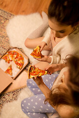 Image showing happy female friends eating pizza at home