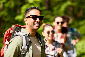 Image showing group of friends with backpacks hiking in forest