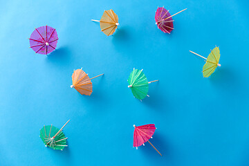 Image showing cocktail umbrellas on blue background