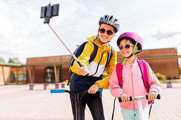 Image showing happy school kids with scooters taking selfie