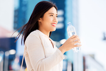 Image showing asian woman drinking water from bottle in city