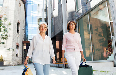 Image showing senior women with shopping bags walking in city