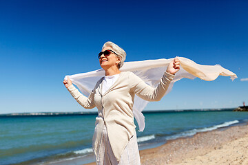 Image showing senior woman with waving scarf on beach in estonia