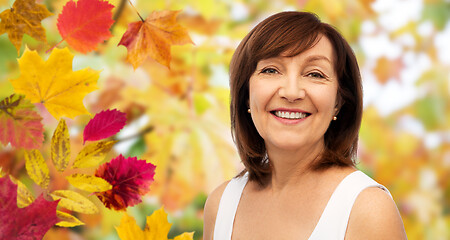 Image showing portrait of happy senior woman over autumn leaves