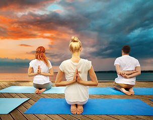 Image showing group of people making yoga exercises outdoors