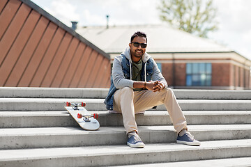 Image showing indian man with skateboard sitting on stairs