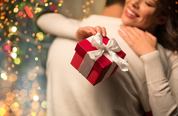 Image showing close up of couple with christmas gift hugging