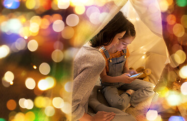 Image showing happy family with smartphone in kids tent at home