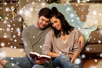 Image showing happy couple reading book at home